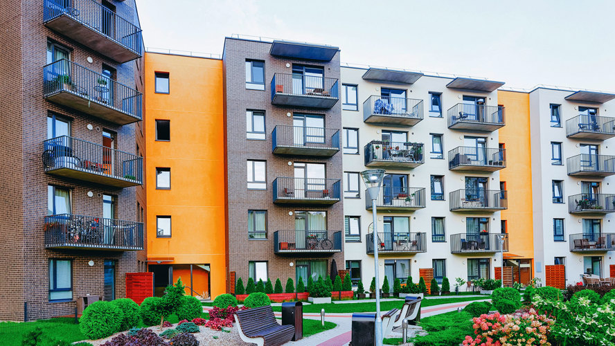 Flera lägenhetshus i orange, brunt och vitt med smidesjärnbalkonger