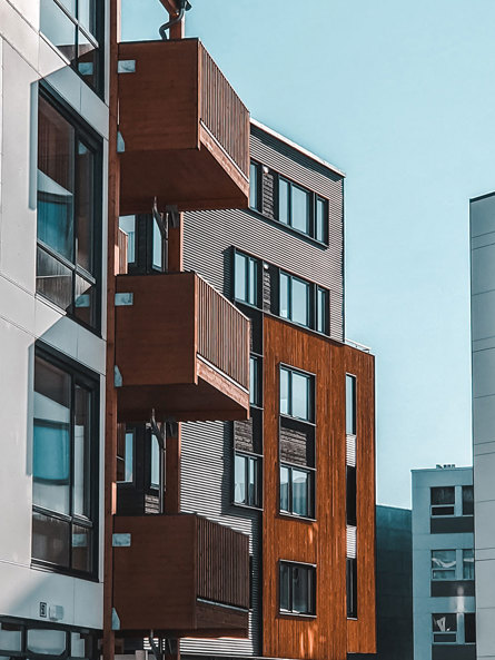 Moderna lägenhetshus i sten och trä, i vitt och brunt